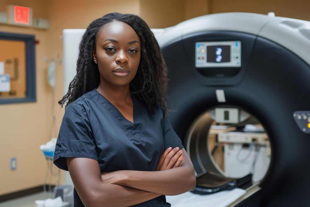 A black radiology technician standing in front a workstation tomography technology equipment.