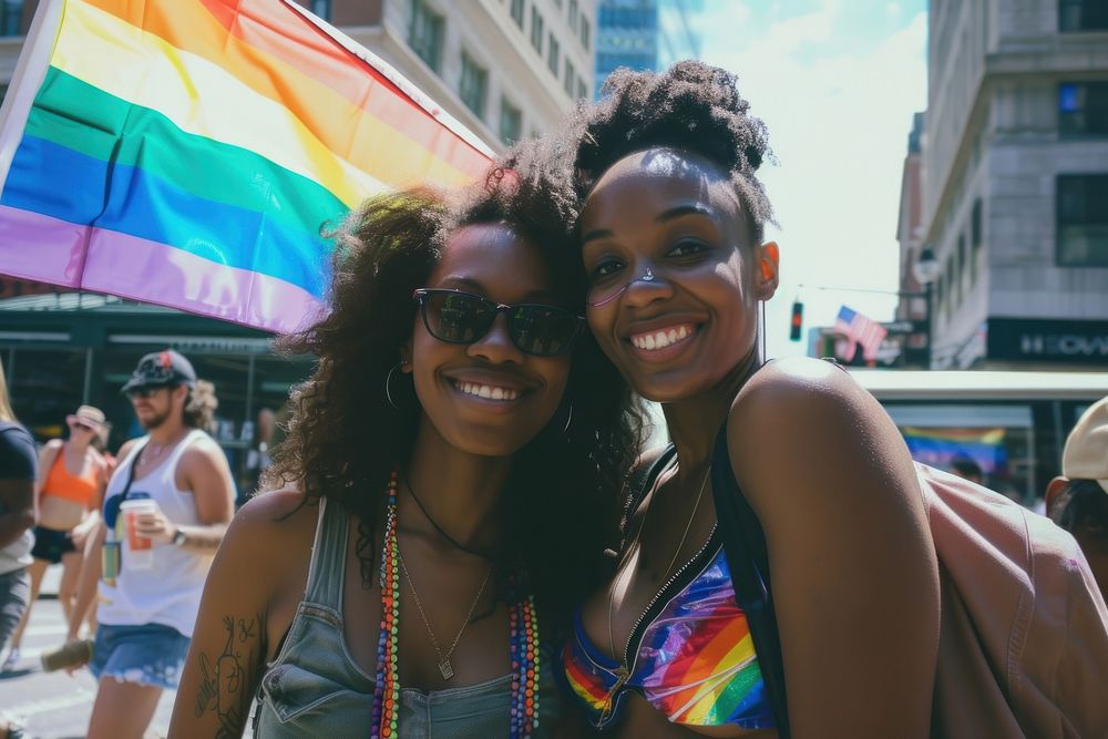 Black couple lesbian woman with gay pride flag on the street photography portrait glasses.