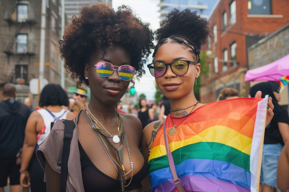 Black couple lesbian woman with gay pride flag on the street sunglasses parade adult.
