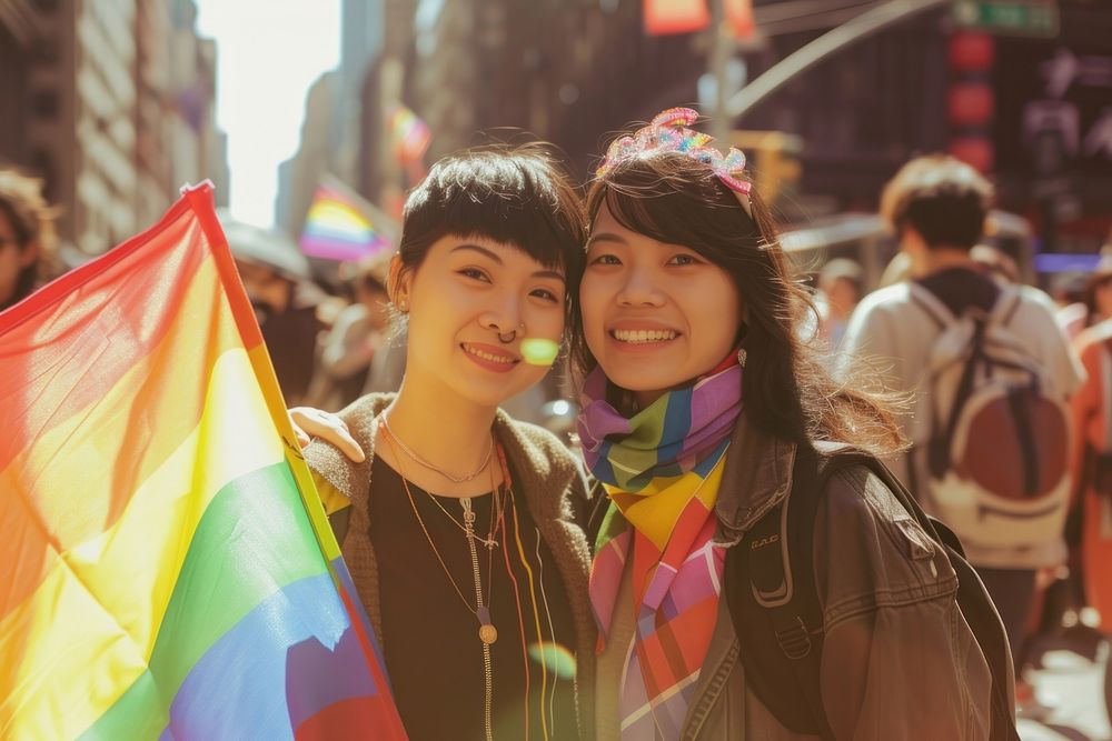 Couple asian lesbian woman with gay pride flag on the street adult togetherness architecture.