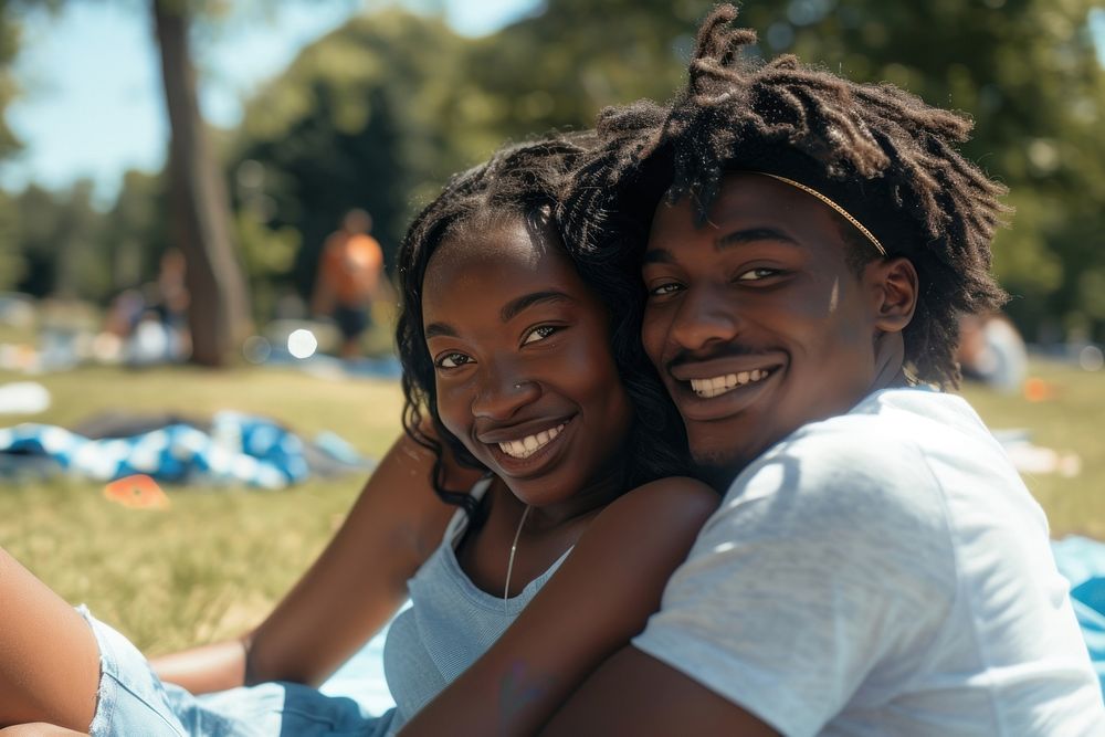 Couple of happy young black adult picnic photography laughing outdoors.