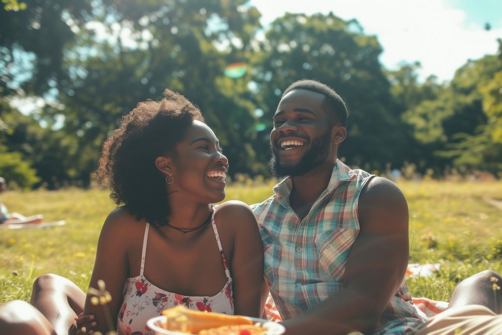 Couple of happy young black adult picnic laughing togetherness celebration.