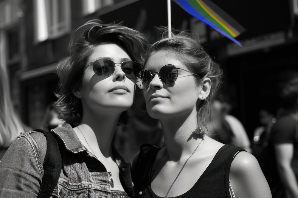 Couple lesbian woman with gay pride flag on the street photography sunglasses portrait.