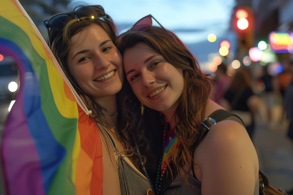 Couple lesbian woman with gay pride flag on the street photography portrait glasses.