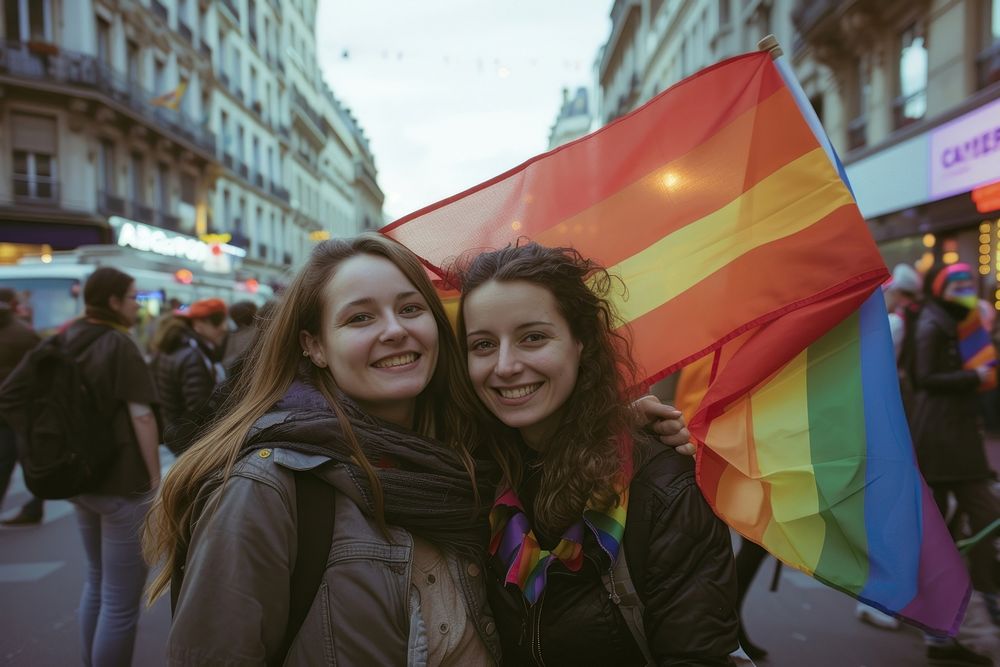 Couple lesbian woman with gay pride flag on the street adult transportation togetherness.