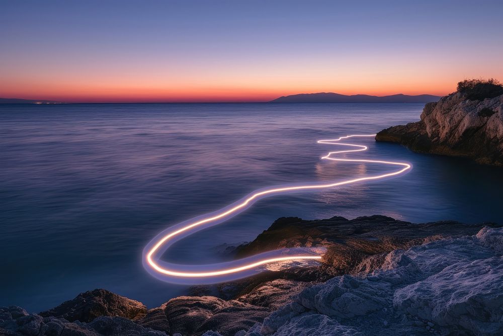 Light line painting at the sea during sunset outdoors horizon nature.