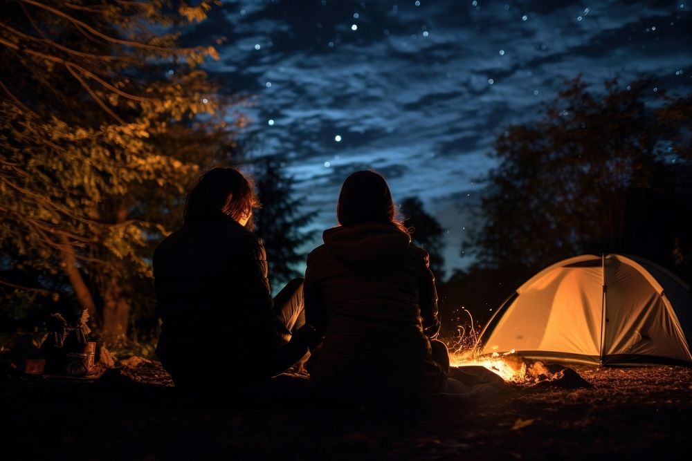 Young couple camping in autumn outdoors nature night.