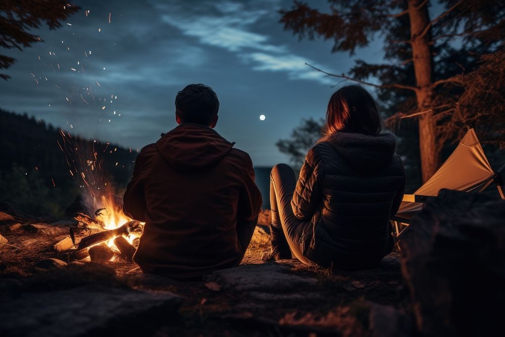Young couple camping in autumn fire outdoors bonfire.