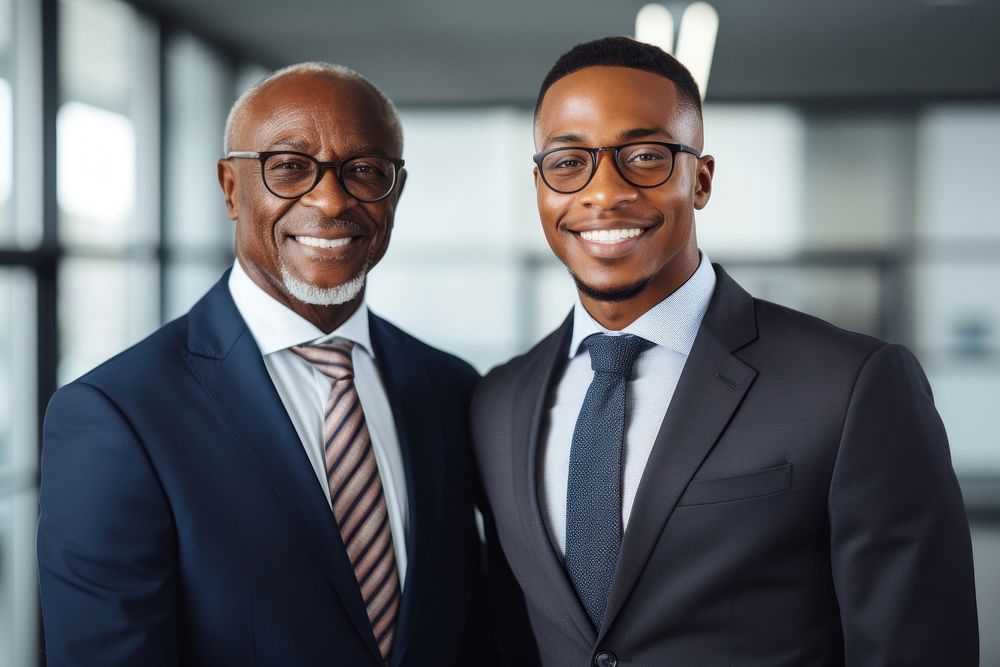 African businessmen shaking hands standing glasses smiling.