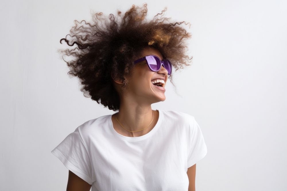 Woman with afro hair and glasses wearing laughing portrait smiling.