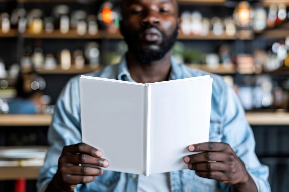Black man reading empty white book and show cover book up in front view publication adult refreshment.