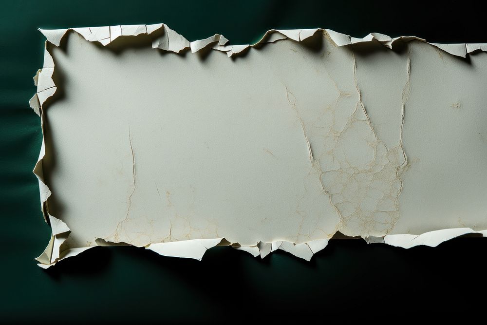 Torn strip of green paper border white weathered furniture.