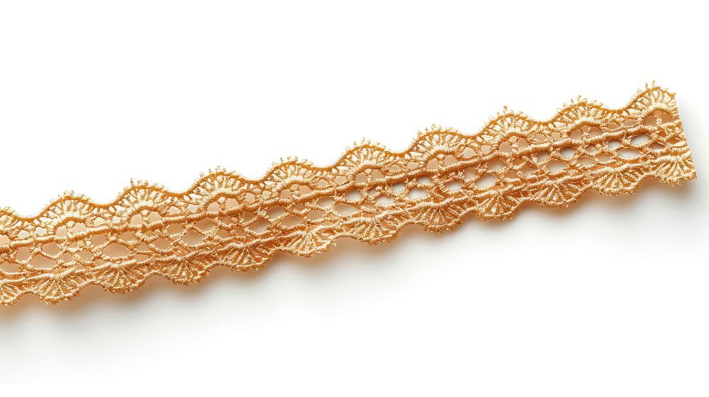 Gold crochet lace tape adhesive strip white background textured textile.