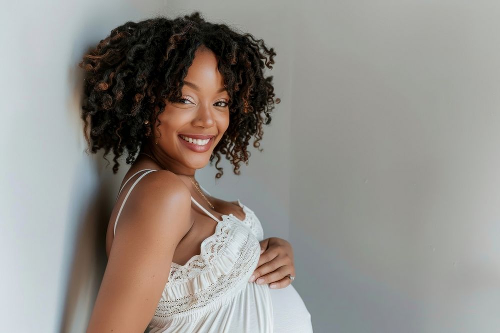 Happy pregnant black woman having a photoshoot smile anticipation studio shot.