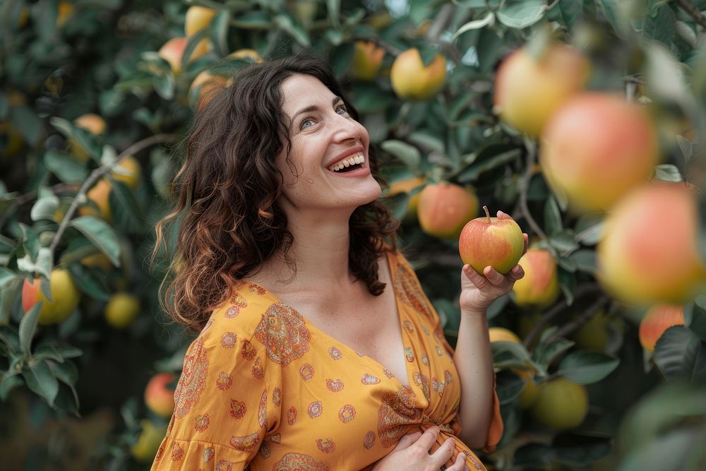 Happy pregnant woman apple plant fruit.