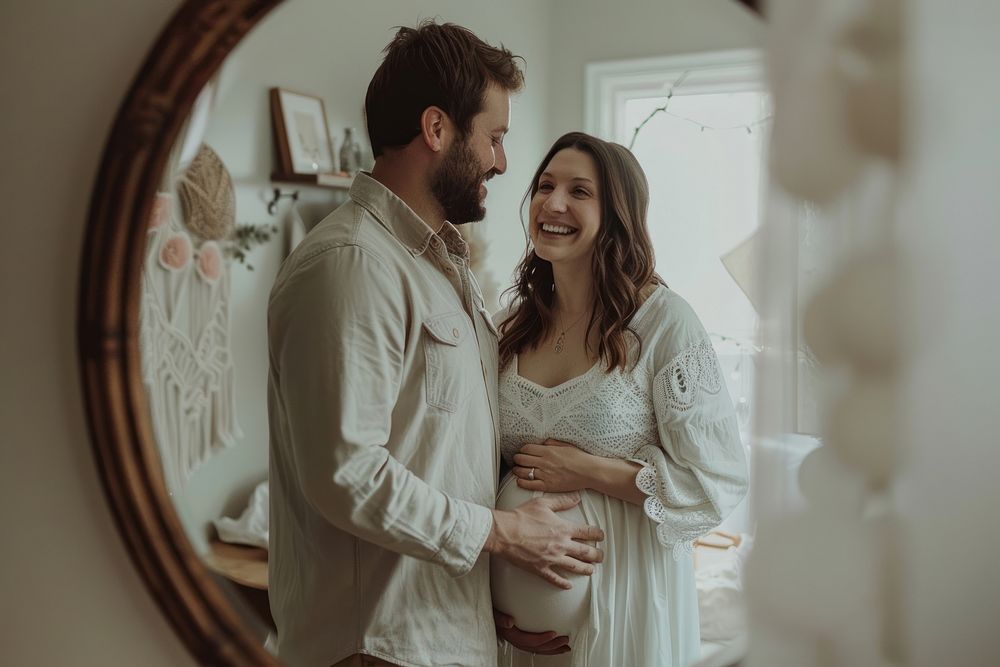 Happy pregnant woman talking a selfie in a mirror with husband adult photo togetherness.