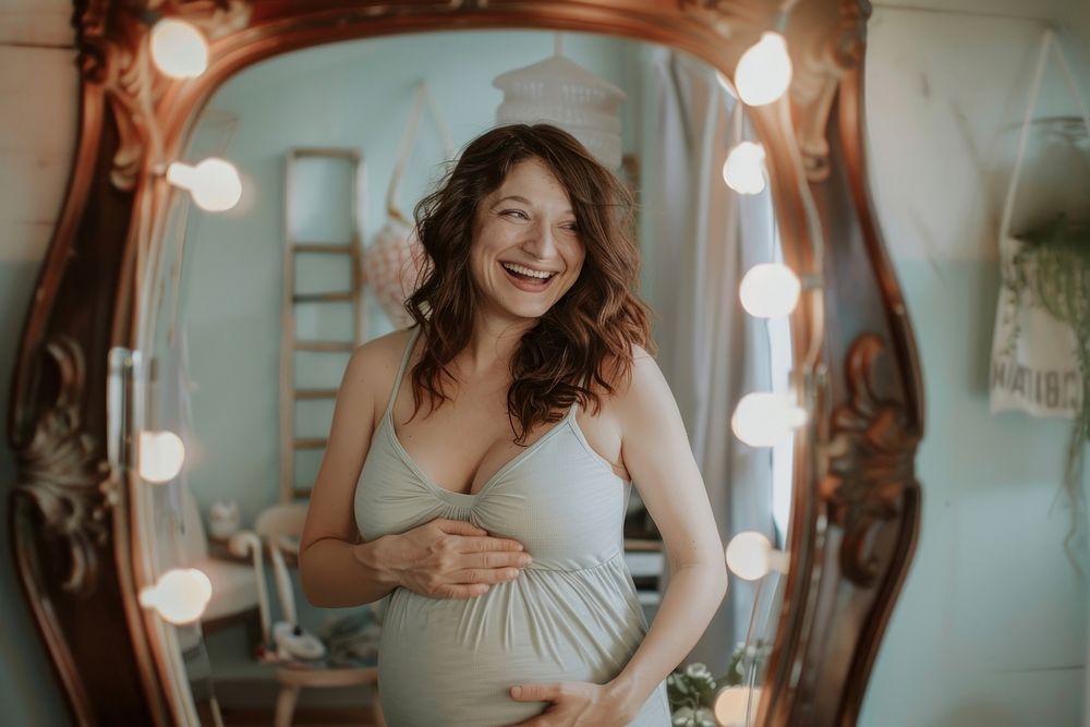 Happy pregnant woman talking a selfie in a mirror adult smile photo.