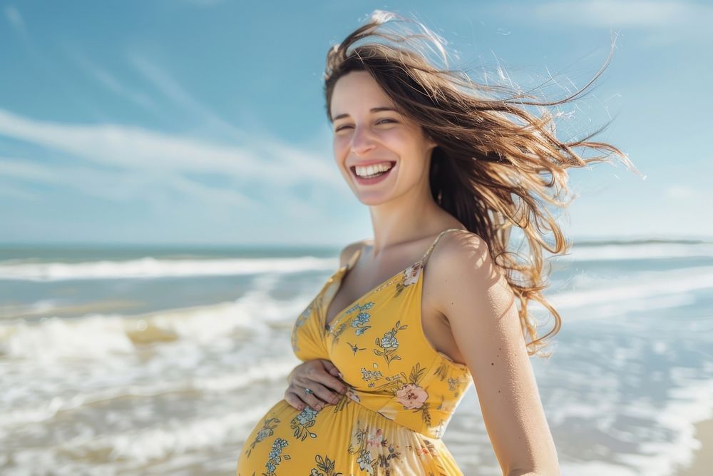 Happy pregnant woman walking at the beach laughing smile adult.