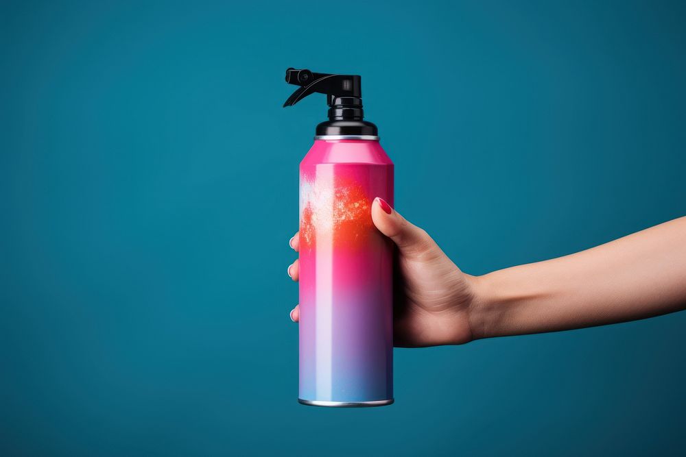 Hand holding spray can cosmetics bottle container.