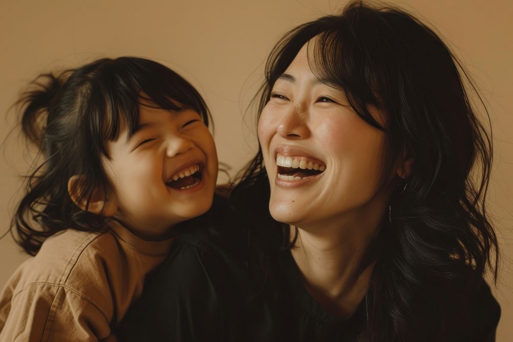 Woman laughing with her daughter adult smile baby.