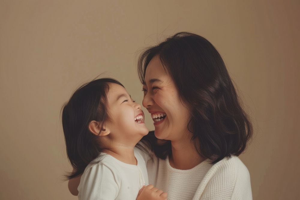 Woman laughing with her daughter child adult affectionate.