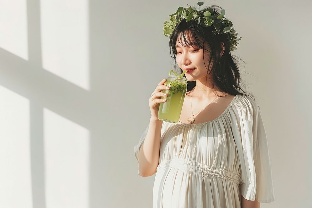 Healthy asian pregnant woman drinking food refreshment.