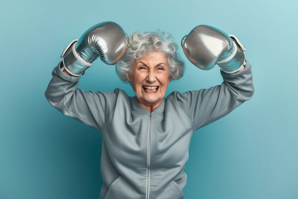 Female in activewear raising hands in silver shining boxing gloves cheerful portrait adult.