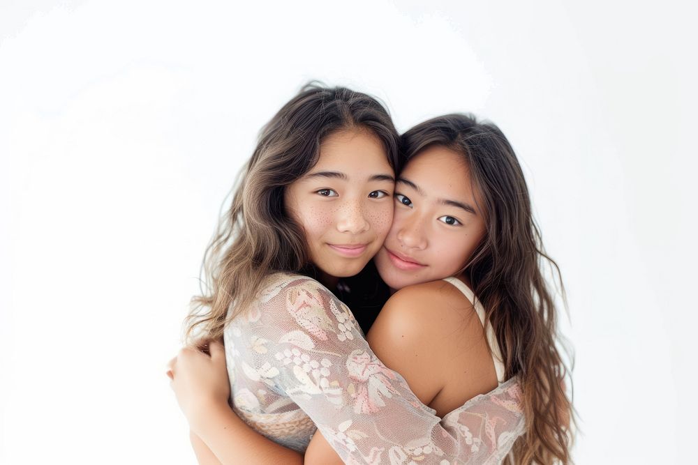 Two asian young women hugging portrait adult white background.