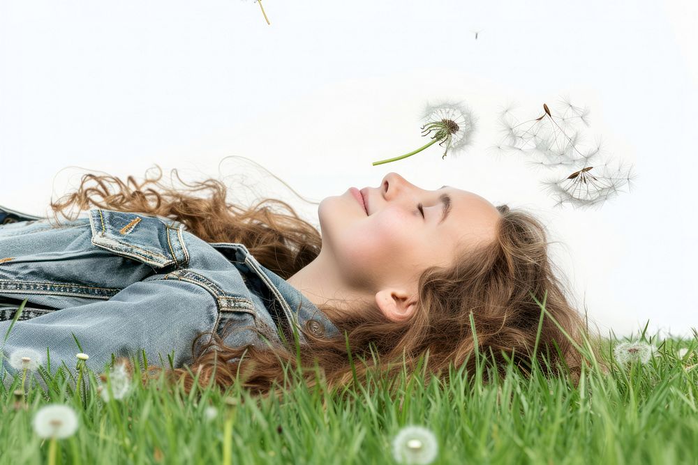 Young woman lying down on the field in green grass dandelion smiling flower.