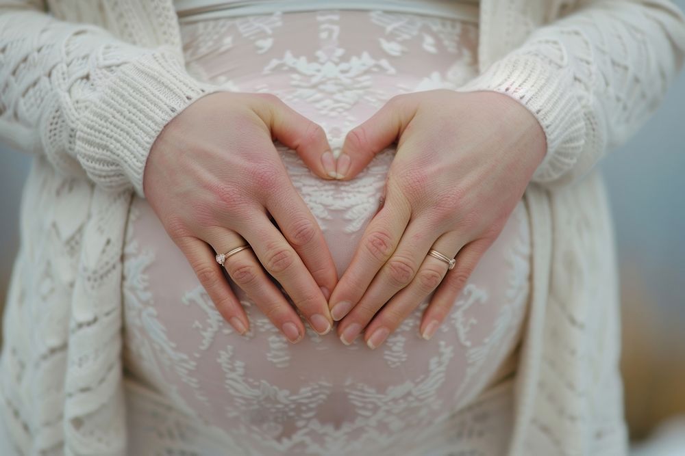 Pregnant woman holding her belly hand jewelry wedding.