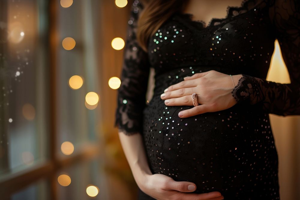 Pregnant woman holding her belly hand jewelry finger.
