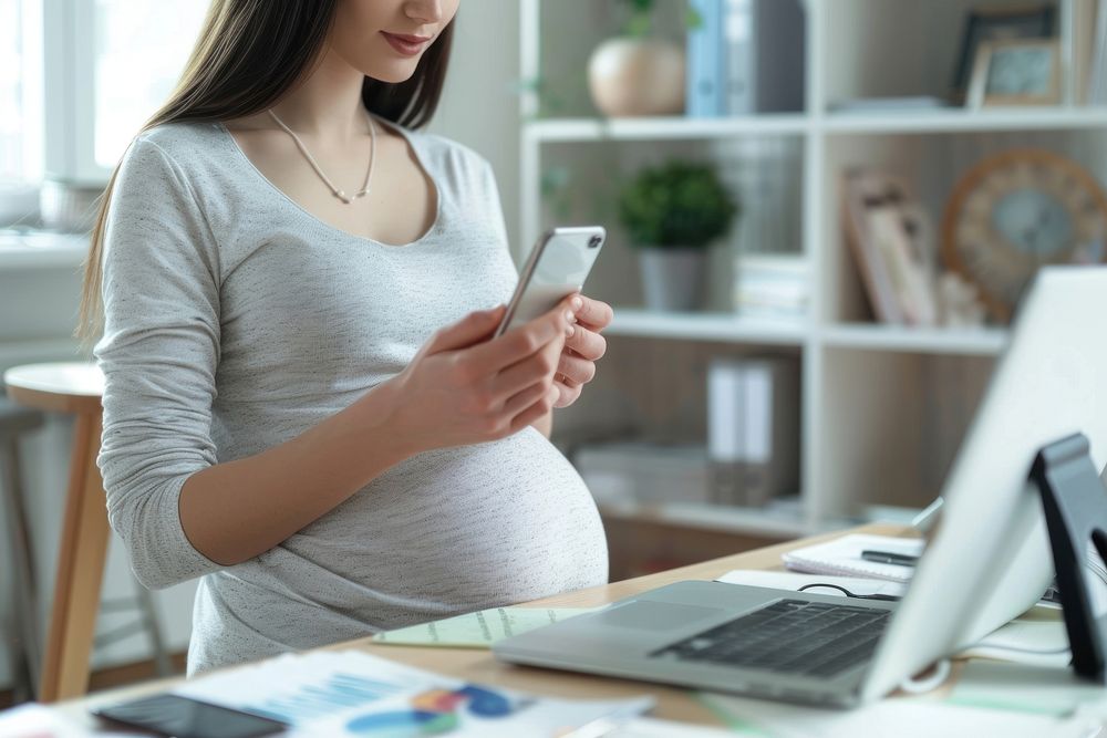 Pregnant woman checking computer phone anticipation.