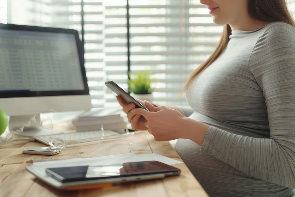 Pregnant woman checking desk computer working.