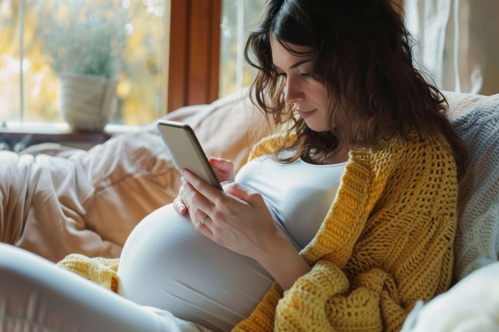 Pregnant woman checking adult phone anticipation.