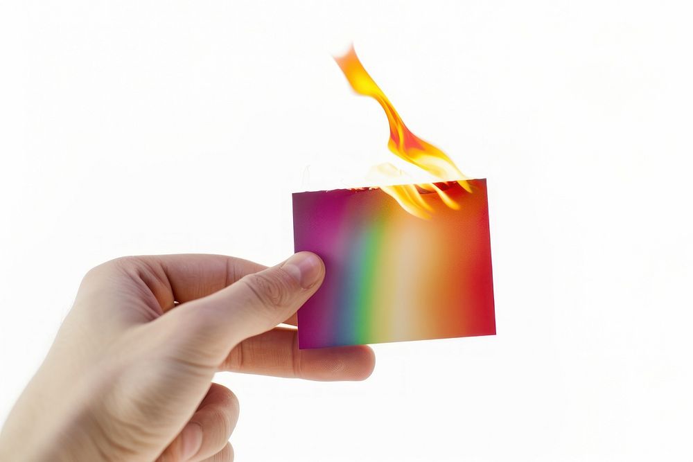 Fingers hold rainbow namecard burning flame fire.