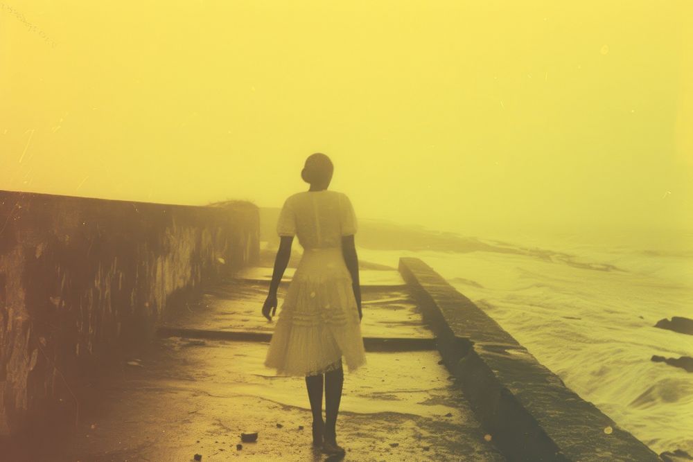 African woman walking on walkpath by sea standing outdoors nature.