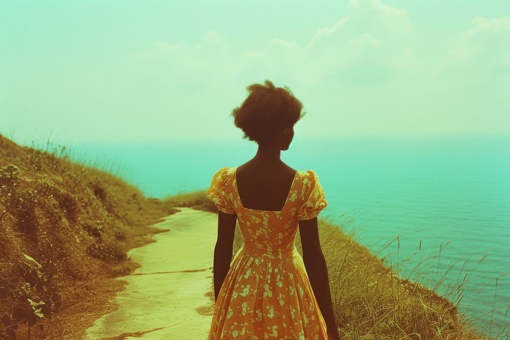 African woman walking on walkpath by sea adult contemplation tranquility.