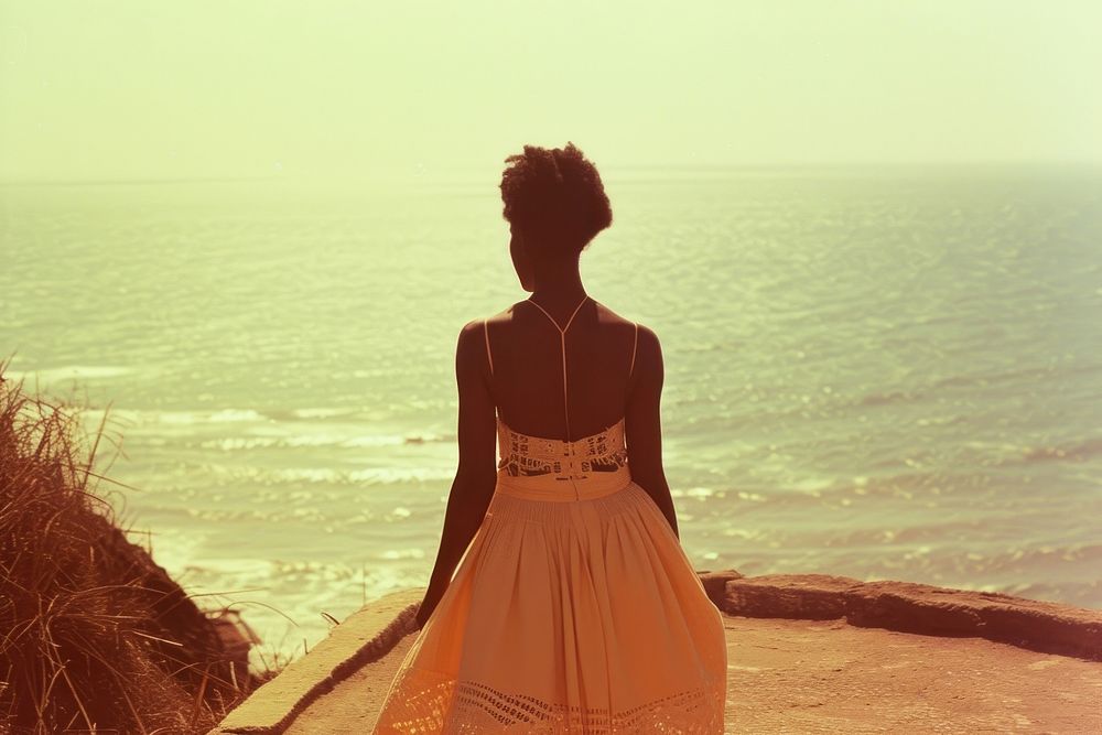 African woman walking on walkpath by sea adult contemplation tranquility.