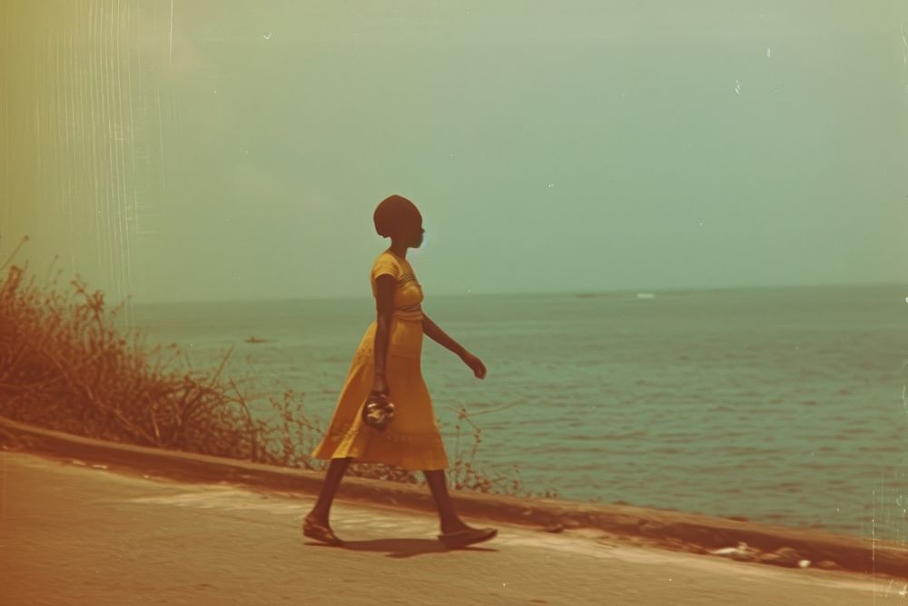 African woman walking on walkpath by sea adult architecture tranquility.