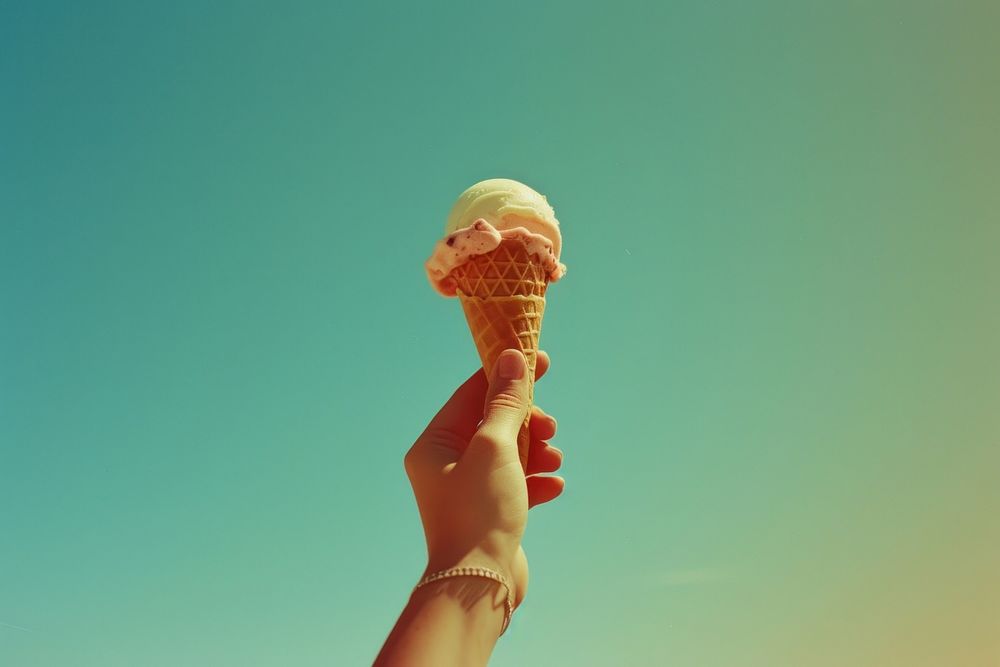 Hand holding icecream cone dessert food lollipop.
