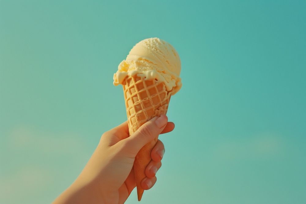 Hand holding icecream cone dessert food freshness.