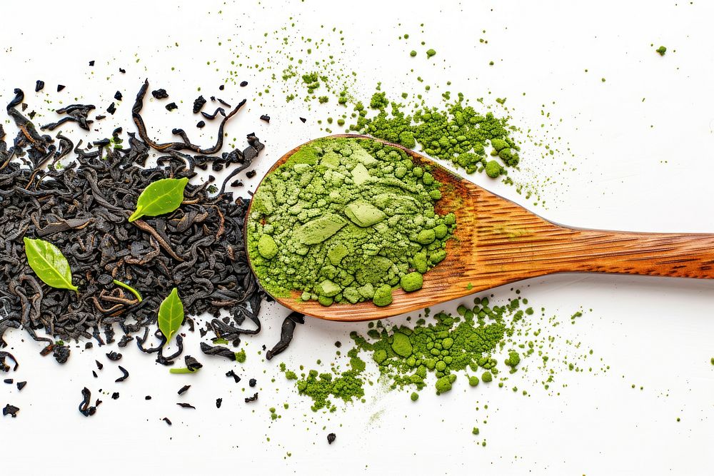 Green matcha powder in a wood spoon with tea leaves spice drink food.