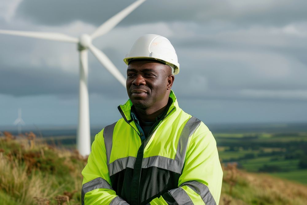 Male engineer wearing hard hat windmill standing outdoors.