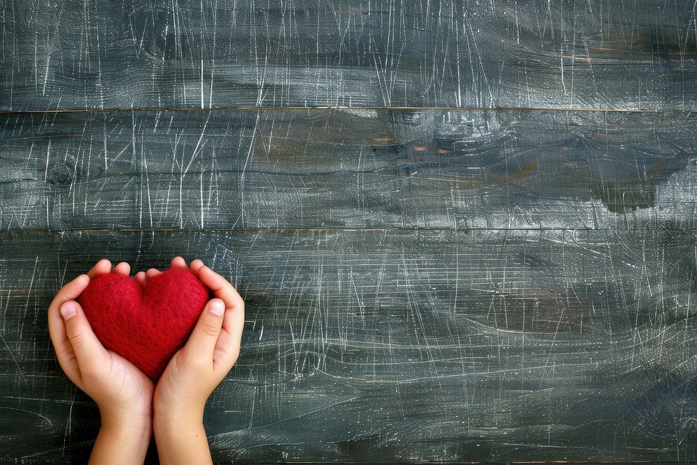 Child hands holding red heart blackboard copy space creativity.