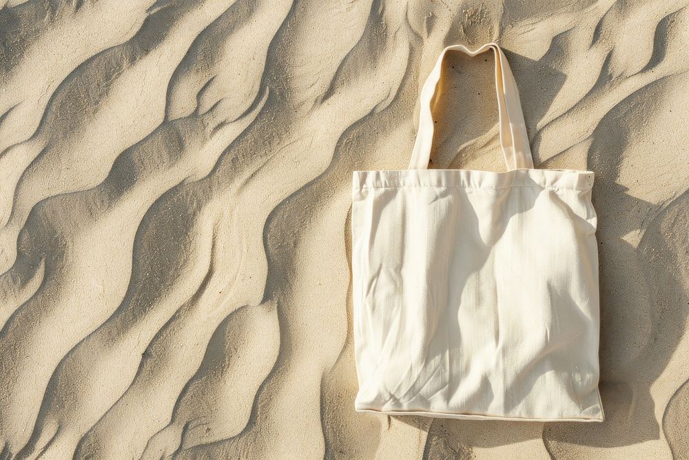 Tote bag on sand backgrounds handbag accessories.