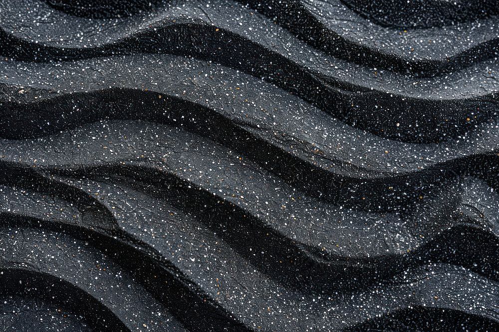 Wave pattern on black sand backgrounds outdoors flooring.