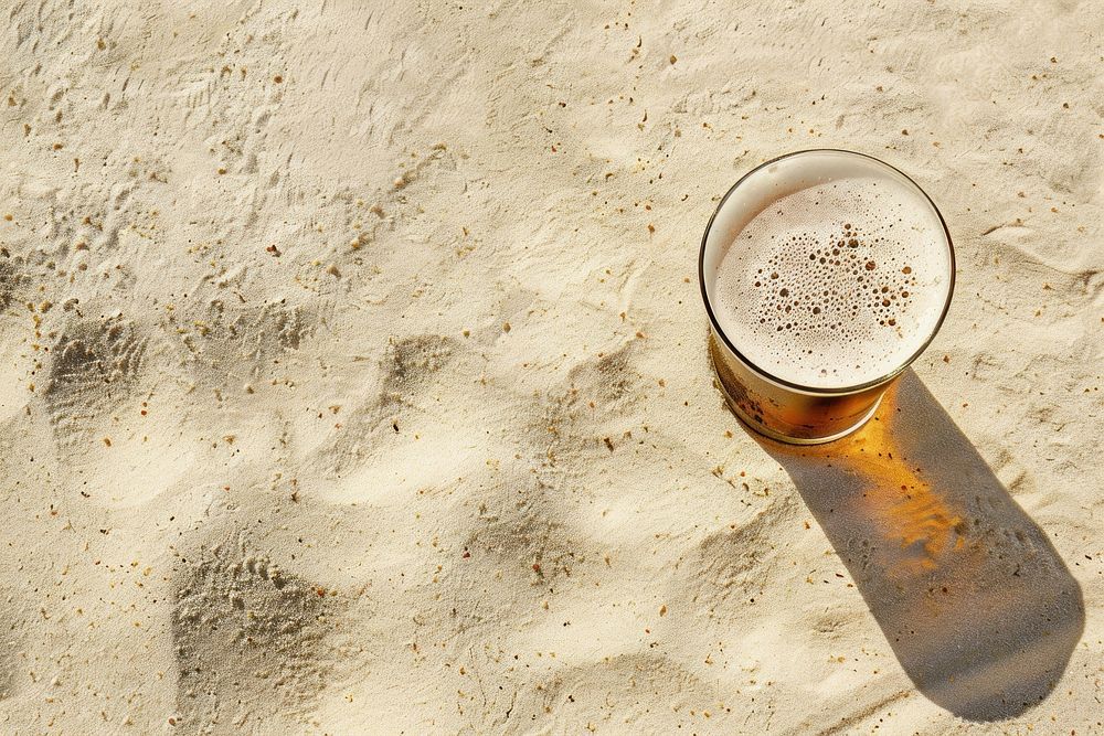 Beer on sand outdoors drink glass.
