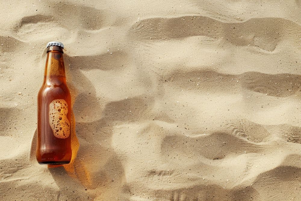 Beer bottle on sand drink condensation refreshment.