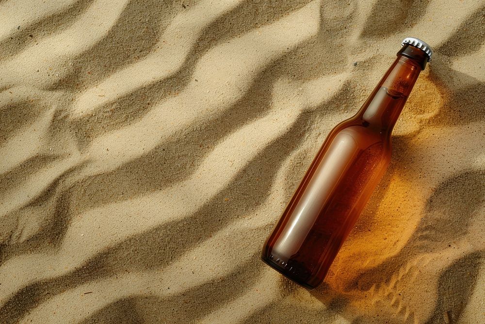 Beer bottle on sand drink refreshment relaxation.