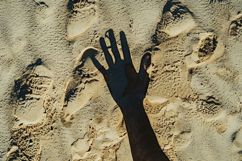 Hand shadow on sand backgrounds outdoors nature.